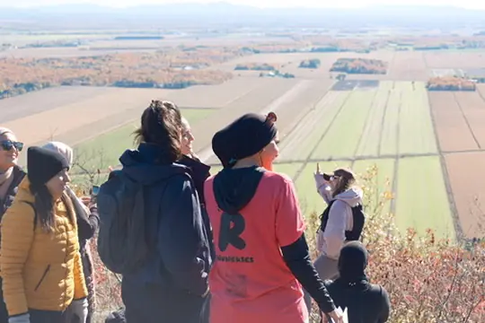 Randonneuses admirant les champs depuis un belvédère