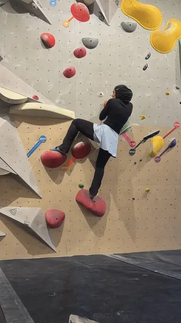 Une membre grimpe sur un mur d’escalade