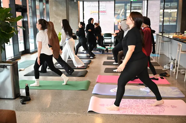 Rangée de femmes en posture debout pendant un cours de pilates entre femmes