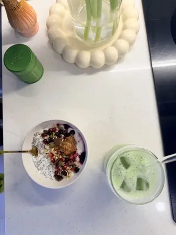 Bol de granola et matcha glacé sur une table blanche