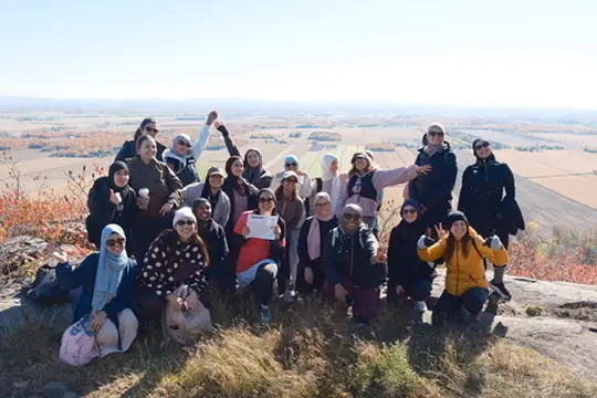 Groupe de randonneuses assises au sommet face à la plaine